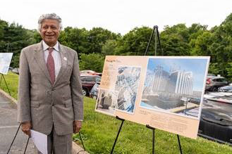 Prabhat Jain in front of a canvas with our Roanoke facility depicted.