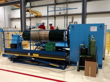 Two men working on a coil winding machine.