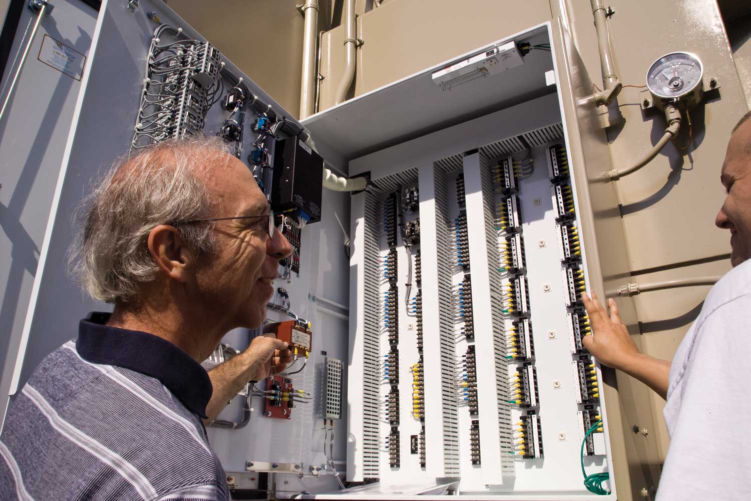 Engineer standing in front of a control box for an electrical transformer.