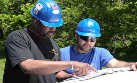 Two field service technicians reviewing transformer manual.