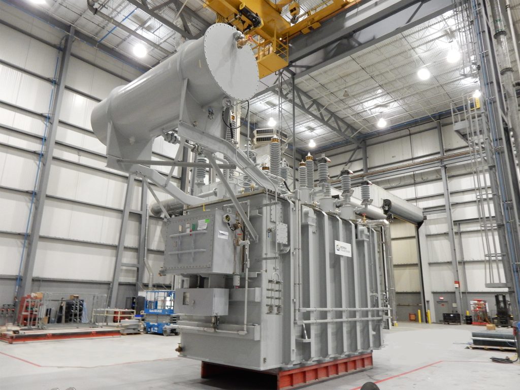 Industrial transformer in a manufacturing building awaiting shipment.